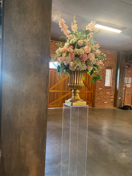 Large gold vase with flower arrangement